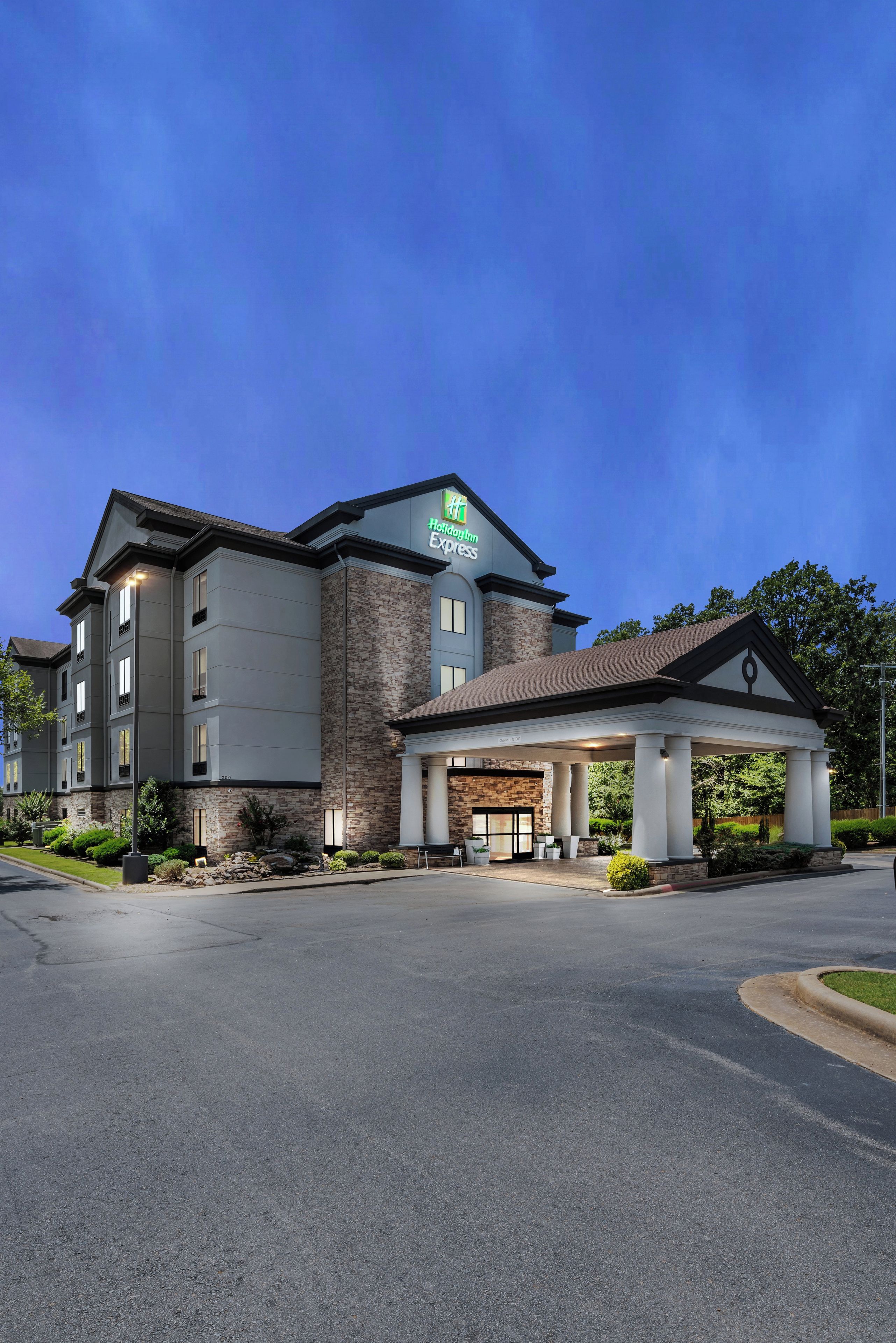 A Holiday Inn Express hotel with a brick facade, a covered entrance, and a well-maintained lawn.