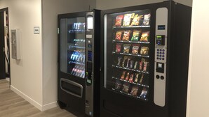 Two vending machines in a hallway with a sign that reads "VENDORS". - WoodSpring Suites Colonial Heights Fort Lee (Colonial Heights)