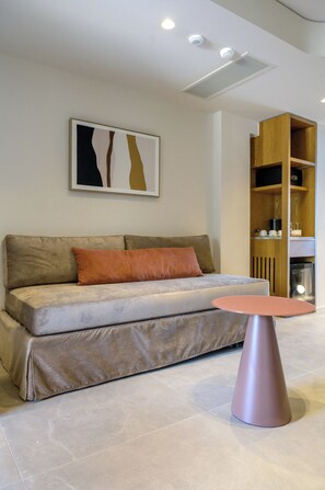Ein modernes Wohnzimmer mit einer Couch, einem Couchtisch und einem an der Wand befestigten Kunstwerk.