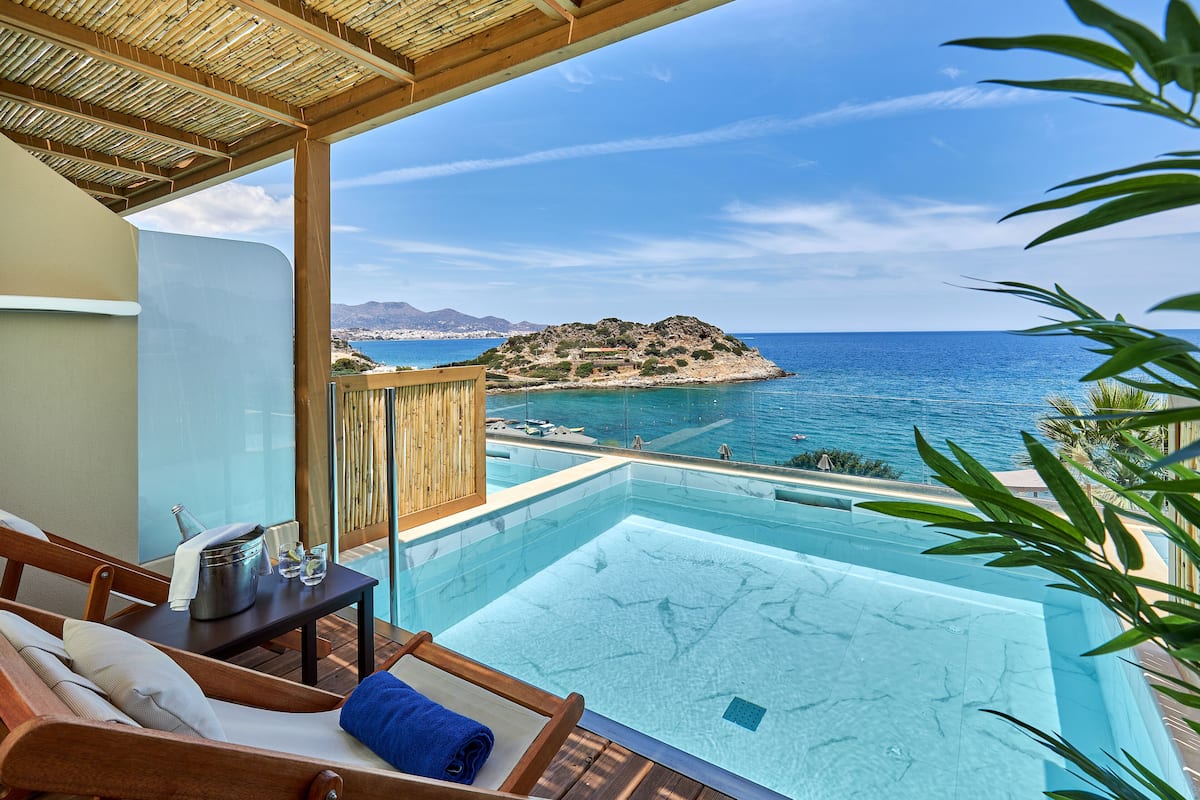 A poolside area with a view of the sea and a distant island.