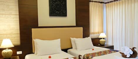 Habitación de hotel con dos camas, un adorno en la pared y cortinas.