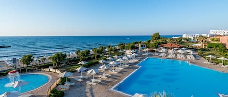 Alberca techada, alberca al aire libre y sombrillas en la alberca