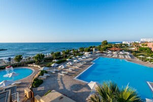 Una piscina cubierta, una piscina al aire libre, sombrillas, tumbonas