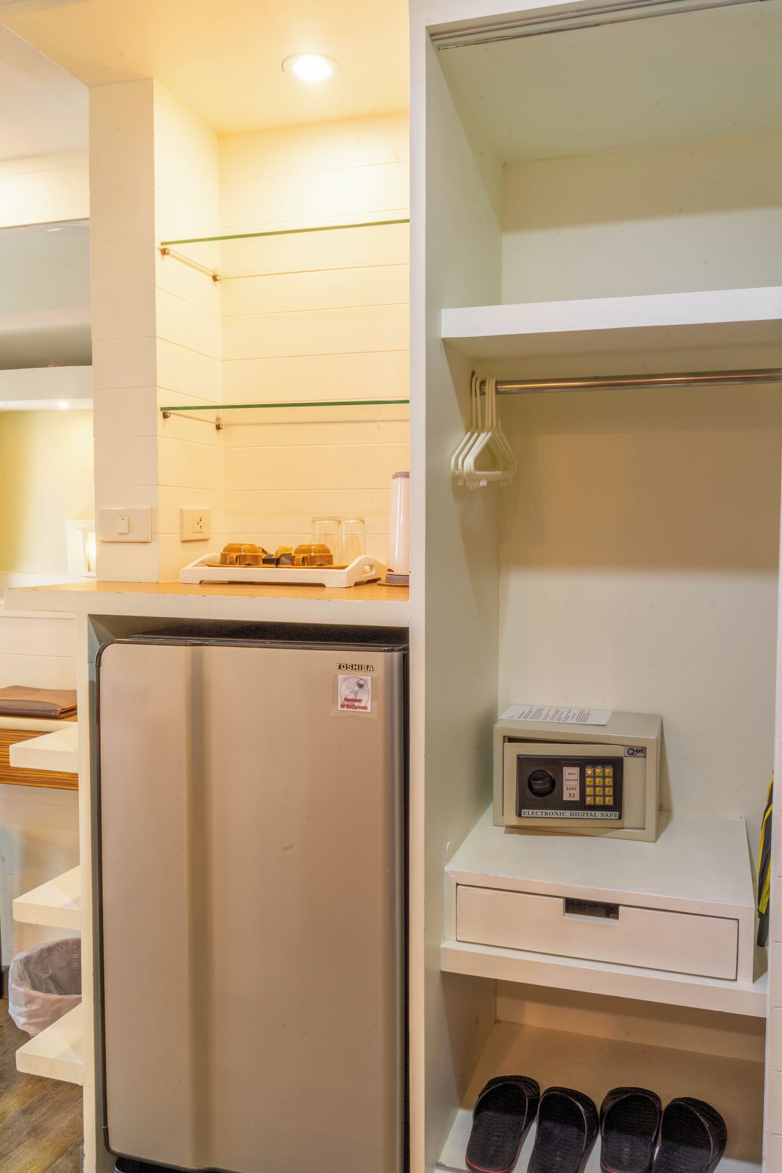 A compact kitchen with a refrigerator, a microwave, and a small coffee maker.