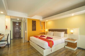 A hotel room with a large bed, bedside tables, a desk, and a chair. - La Vintage Resort (Patong)