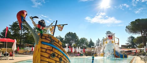 A swimming pool with a large ship-shaped water feature and a parrot statue.