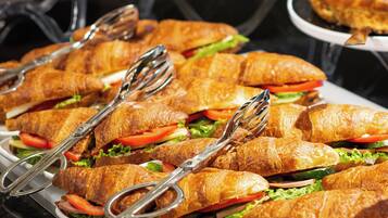 A buffet with various food items including sandwiches and pies.