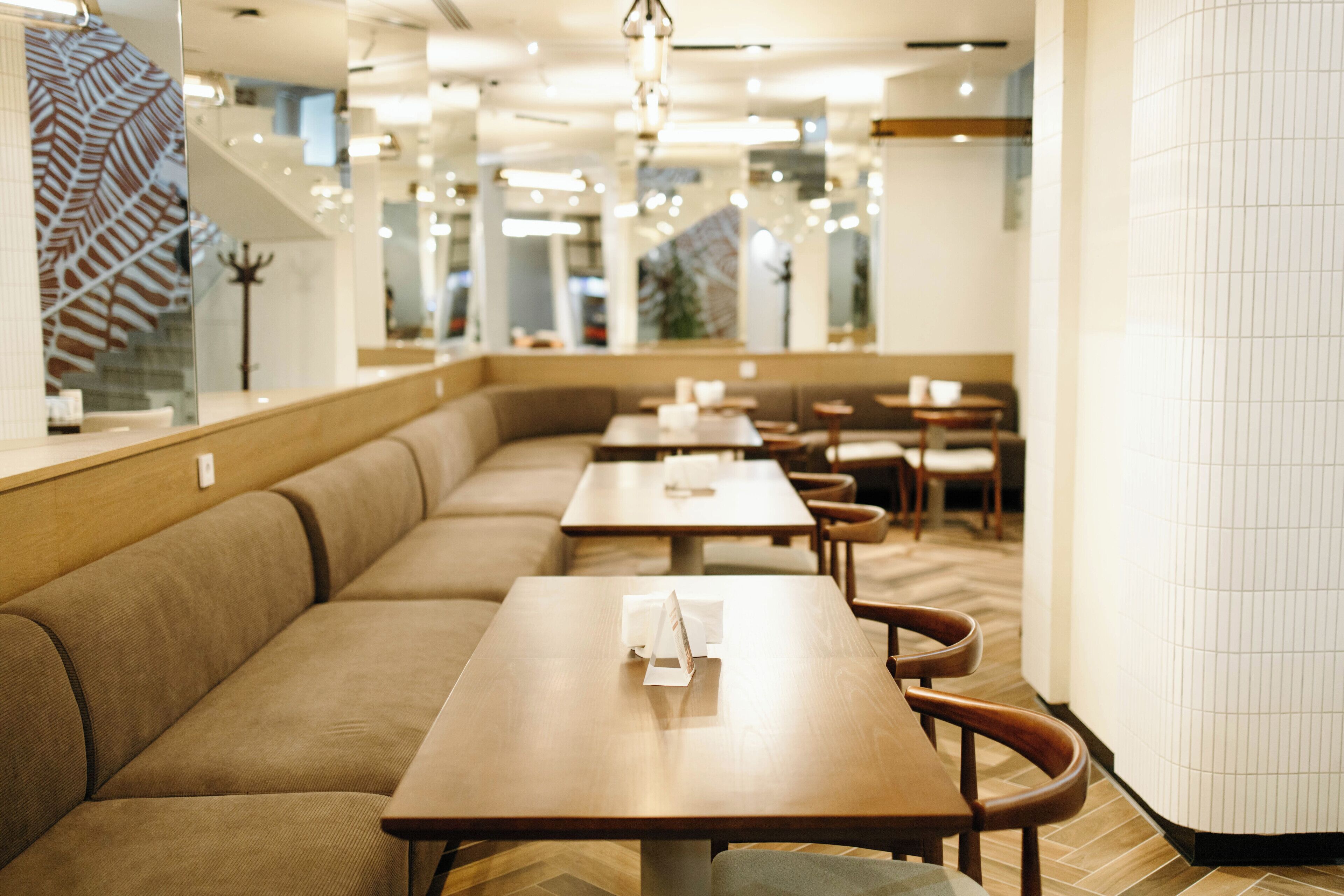 Un restaurant moderne avec un long comptoir, des sièges confortables et un design épuré et contemporain.