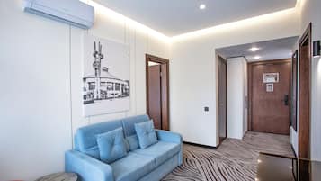 Premium Quadruple Room | Living area | 42-inch TV with cable channels
