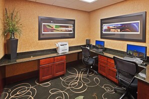 A hotel room with a desk, two chairs, a printer, and two monitors. - Holiday Inn Express Hotel & Suites POTEAU by IHG (Poteau)