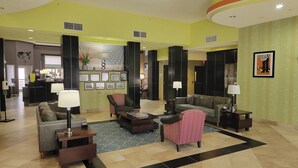 A spacious lobby with a reception desk, multiple seating areas, and a large American flag. - Holiday Inn Garland by IHG (Garland)
