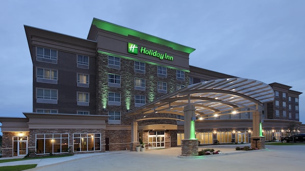 A Holiday Inn hotel with a brick facade, a covered entrance, and a well-lit exterior.