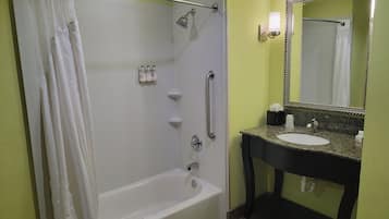 A bathroom with a bathtub, a shower, a sink, and a mirror.