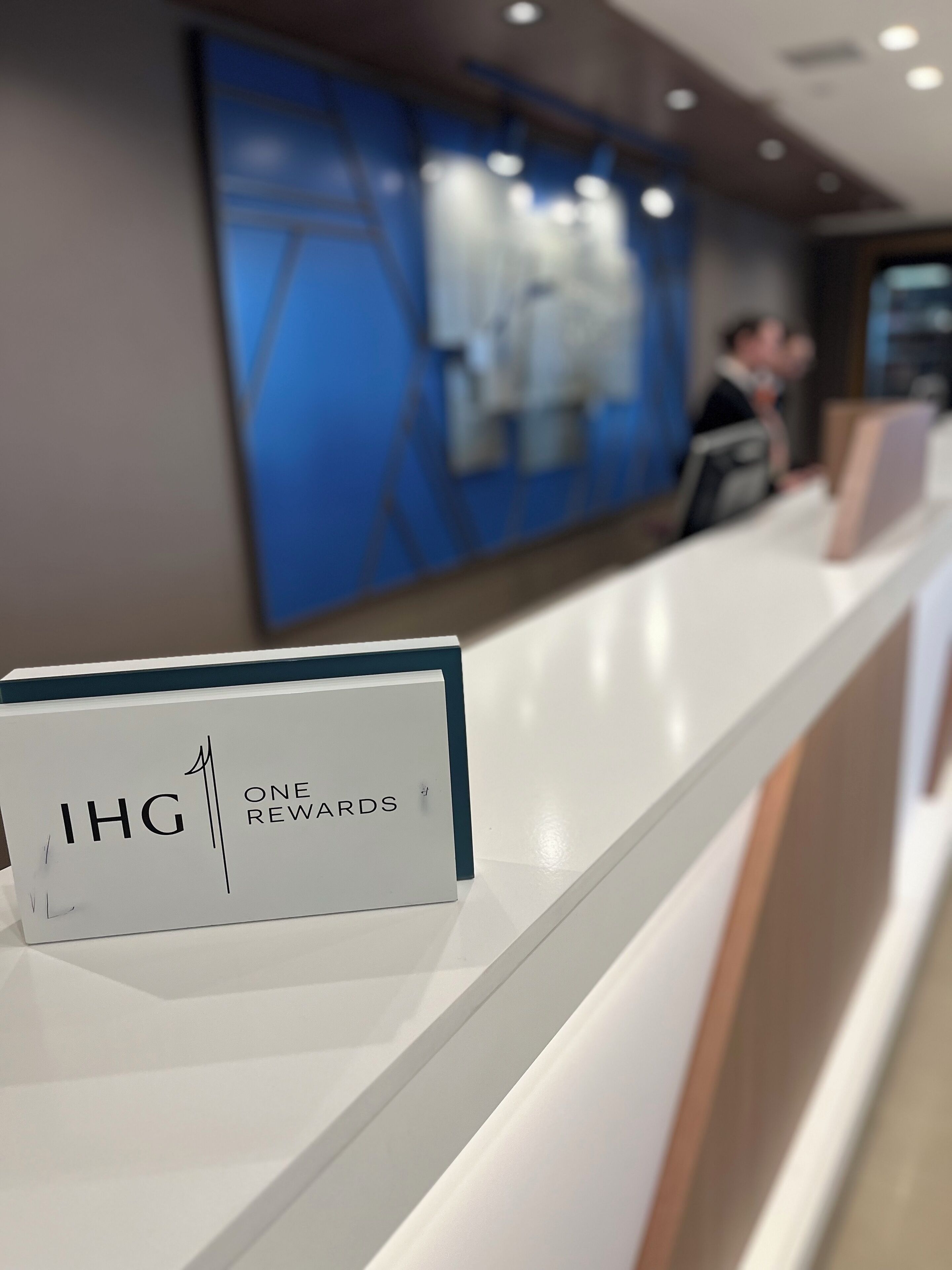 A reception desk with a sign reading "IHG ONE REWARDS".
