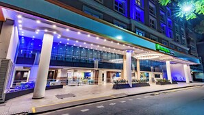 A hotel with a modern facade, large columns, and a well-lit entrance area. - Holiday Inn Express Rosario by IHG (Rosario)