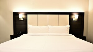 A hotel room with a large bed, two bedside tables, and wall-mounted lamps. - Holiday Inn Express Rosario by IHG (Rosario)