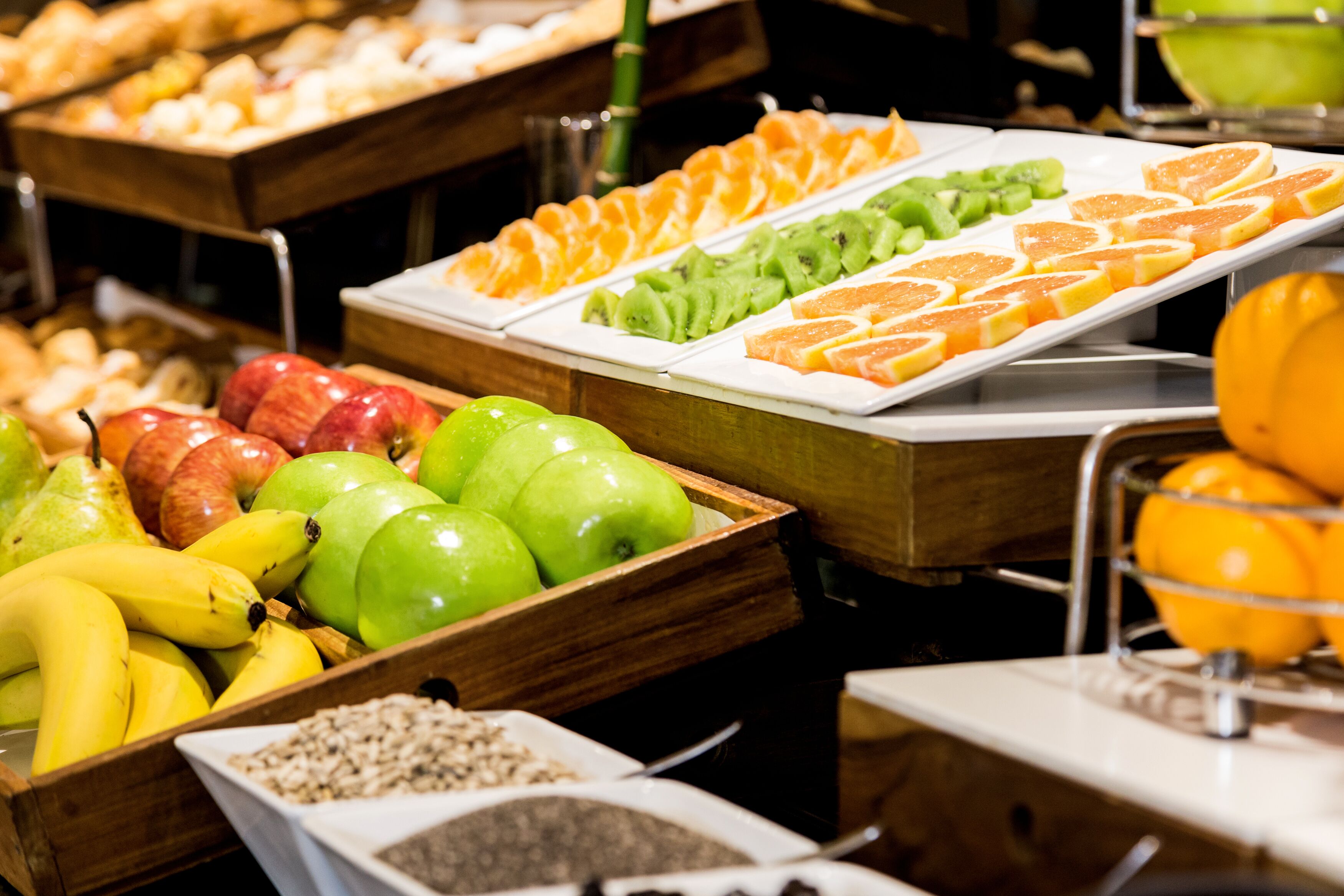 Un bufé con diversas frutas y bollería.