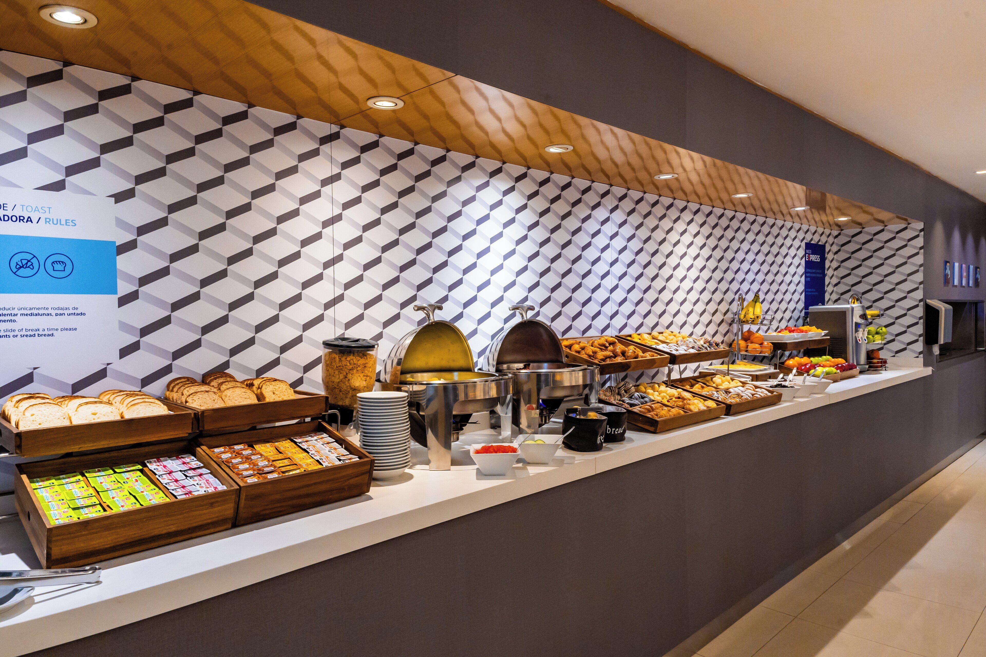 A buffet counter with various food items and a sign indicating rules.
