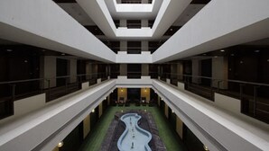 Un atrio de varios niveles con piscina central, balcones y un diseño arquitectónico moderno.
