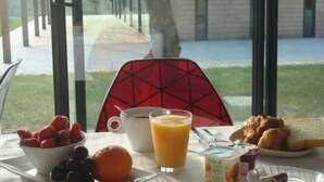 A breakfast table with fruits, a glass of orange juice, and pastries. -  The Originals City, Hôtel Anaïade, Saint-Nazaire-Pornichet (Saint-Nazaire)