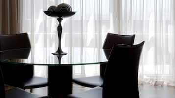 Un comedor con una mesa de vidrio, sillas negras y un cuenco decorativo sobre la mesa.