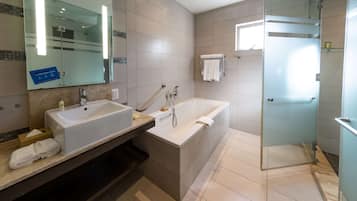 Een moderne badkamer met een dubbele wastafel, een badkuip en een douchecabine met glazen wanden.