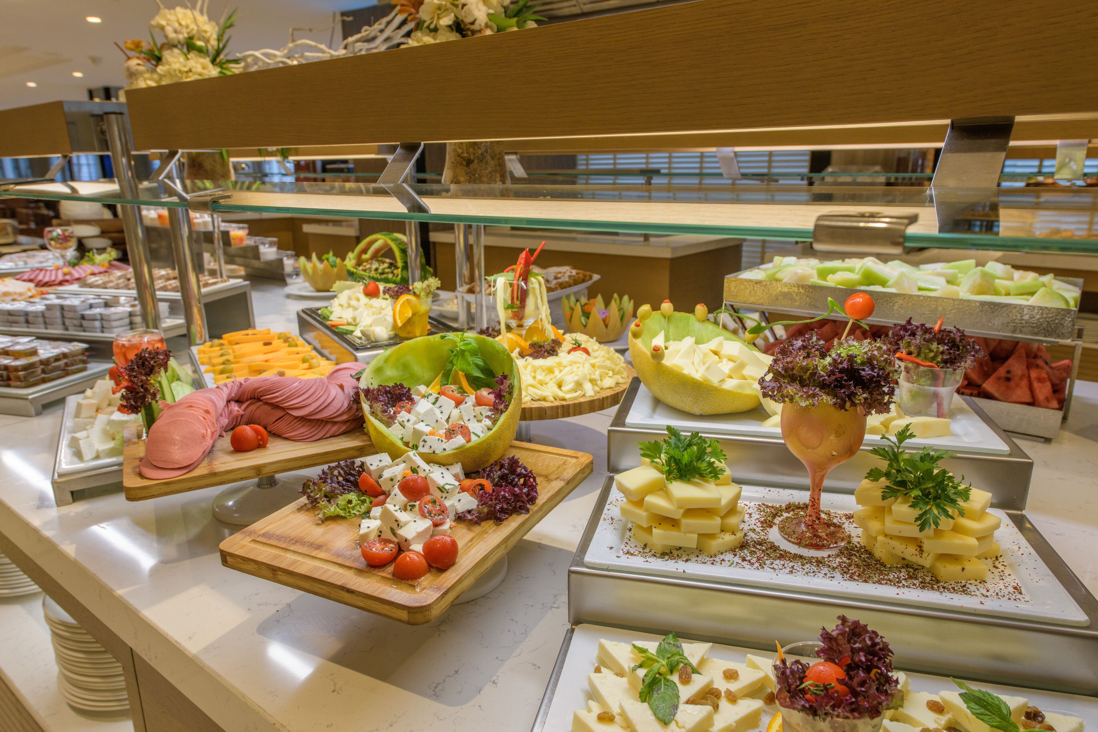 A buffet with various food items including fruits, cheeses, and salads.