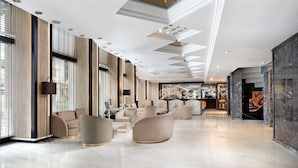 A spacious lobby with a high ceiling, recessed lighting, and a central seating area with sofas and armchairs. - Golden Age Hotel Taksim (Istanbul)