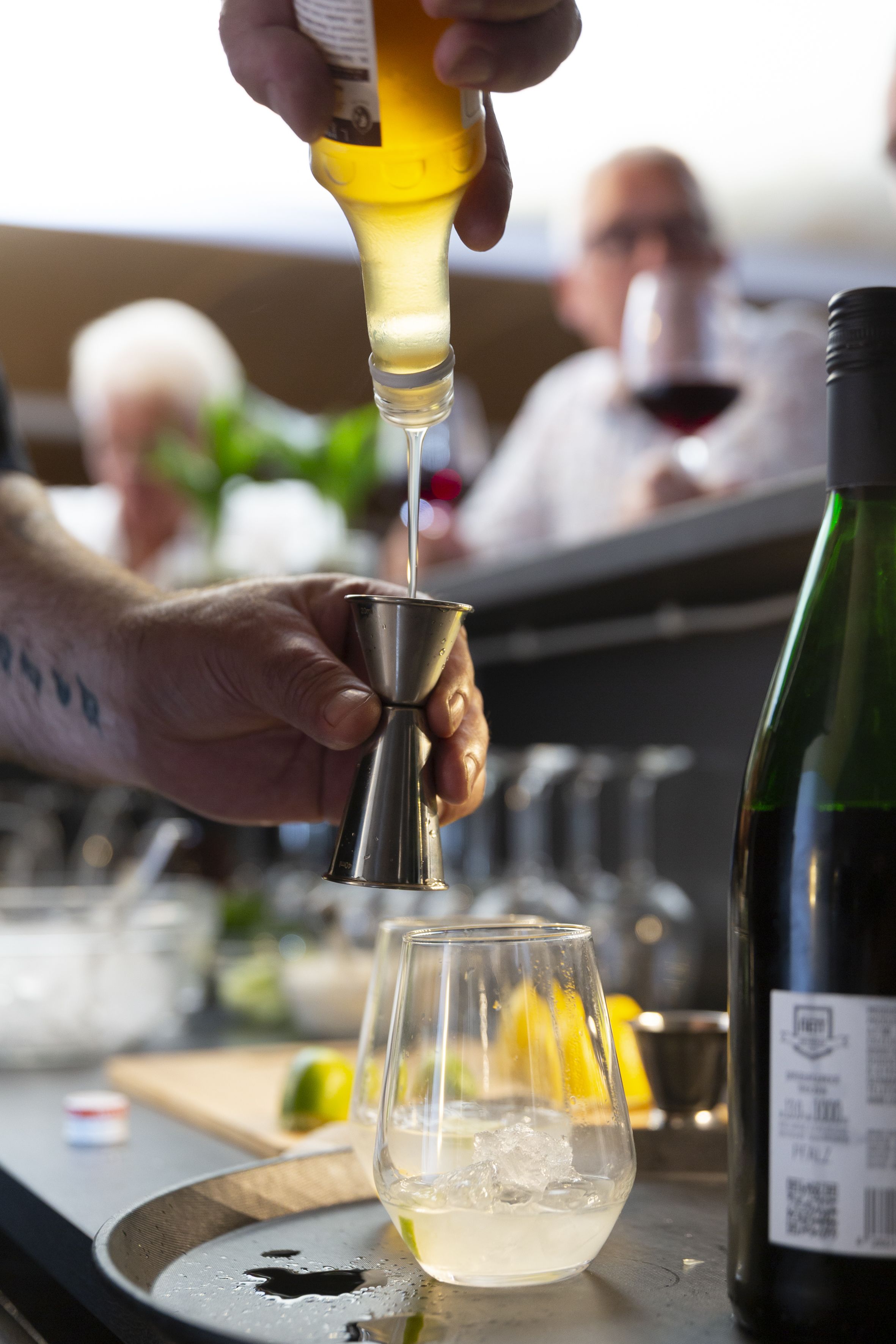 A bartender pouring a drink into a glass.