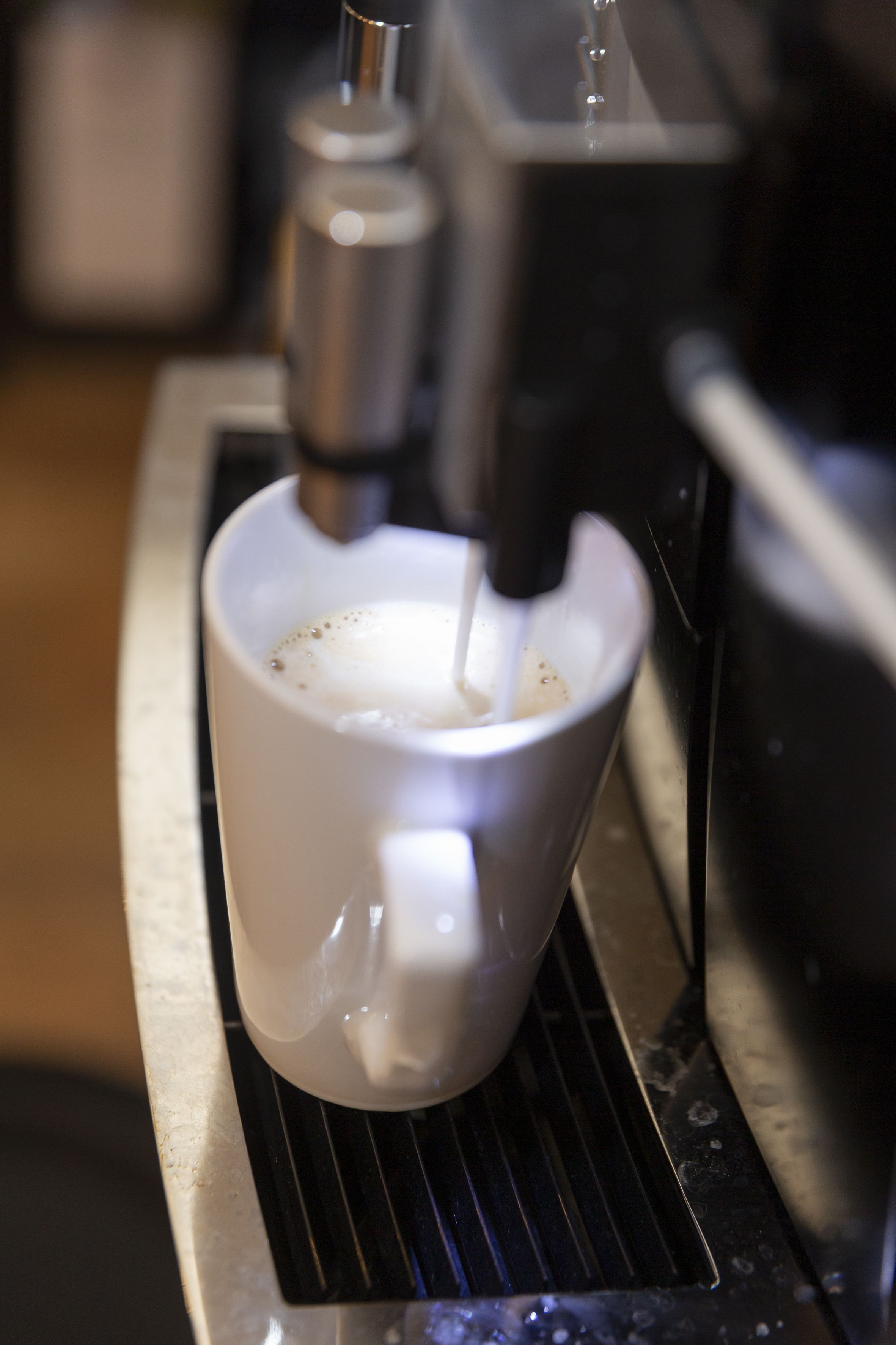 Eine Kaffeemaschine füllt Kaffee in eine Tasse.