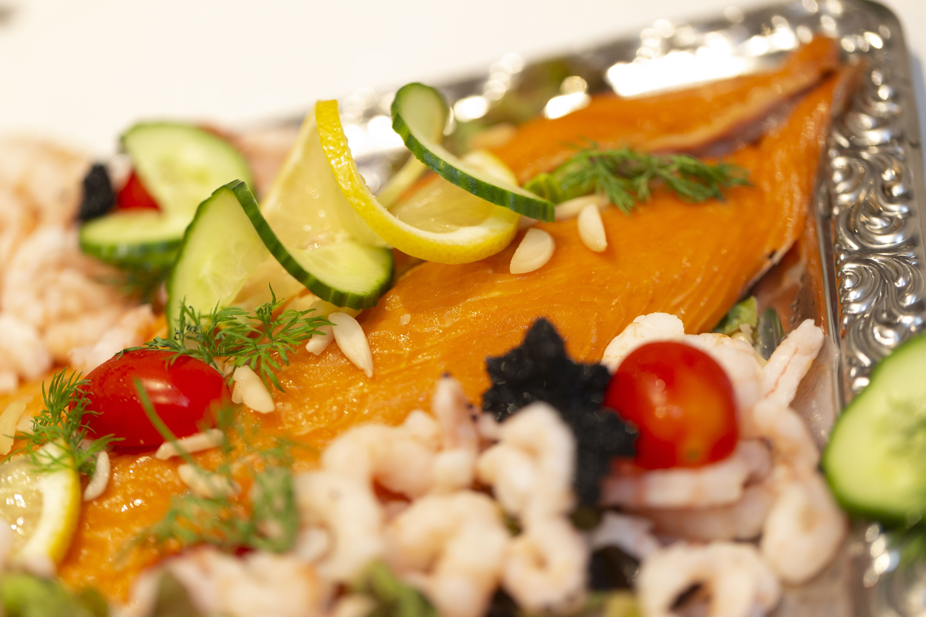 A plate of food with salmon, shrimp, and vegetables.