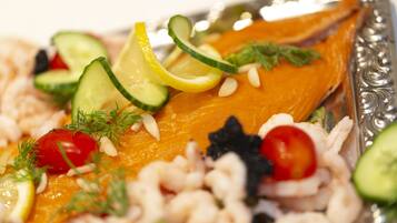 A plate of food with salmon, shrimp, and vegetables.