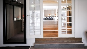 A hotel entrance with a wooden staircase leading to a reception area. - Dolphin Hotel Herning (Herning)