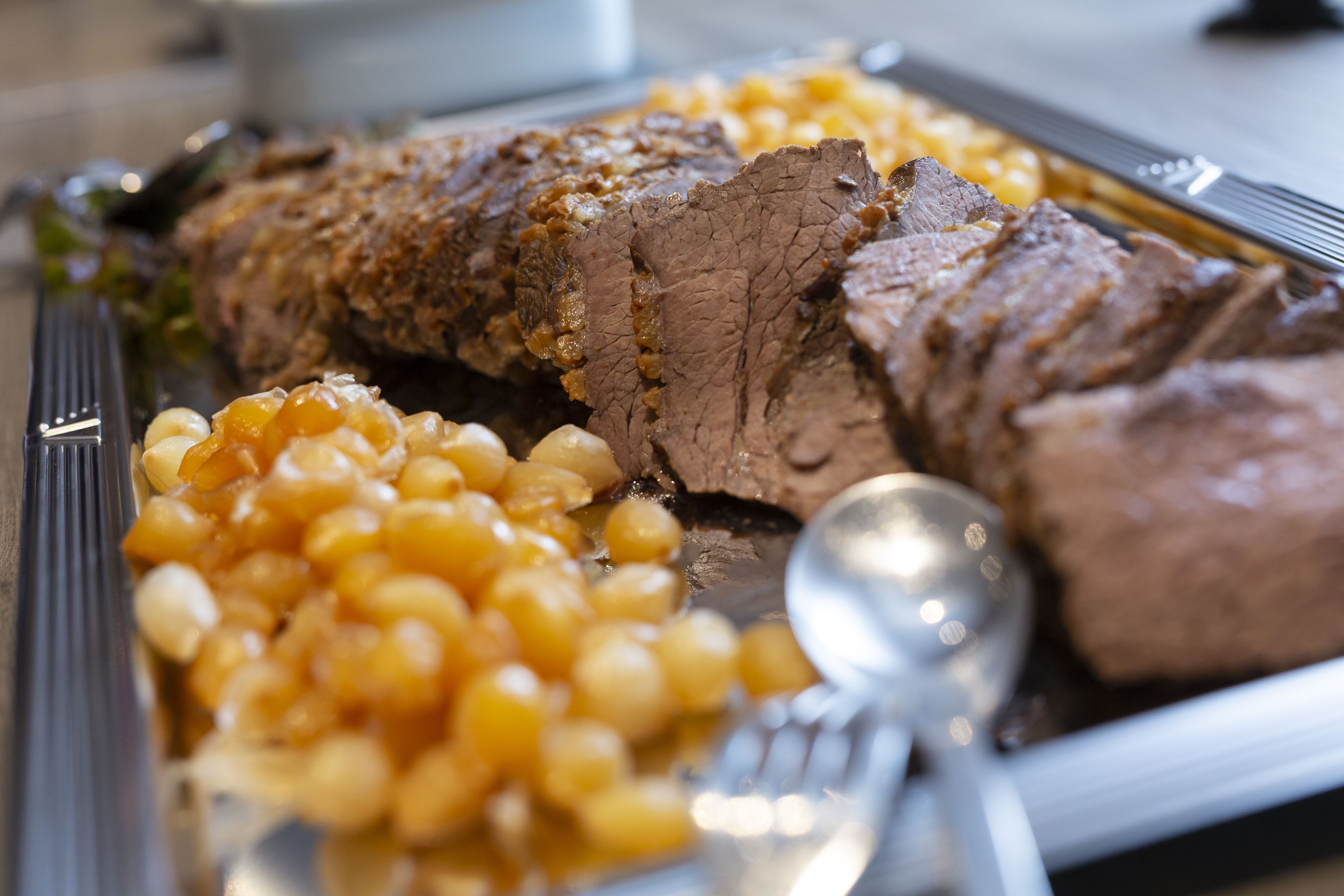A plate with sliced beef and macaroni.