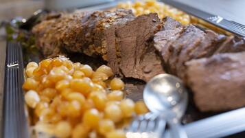 A plate with sliced beef and macaroni.
