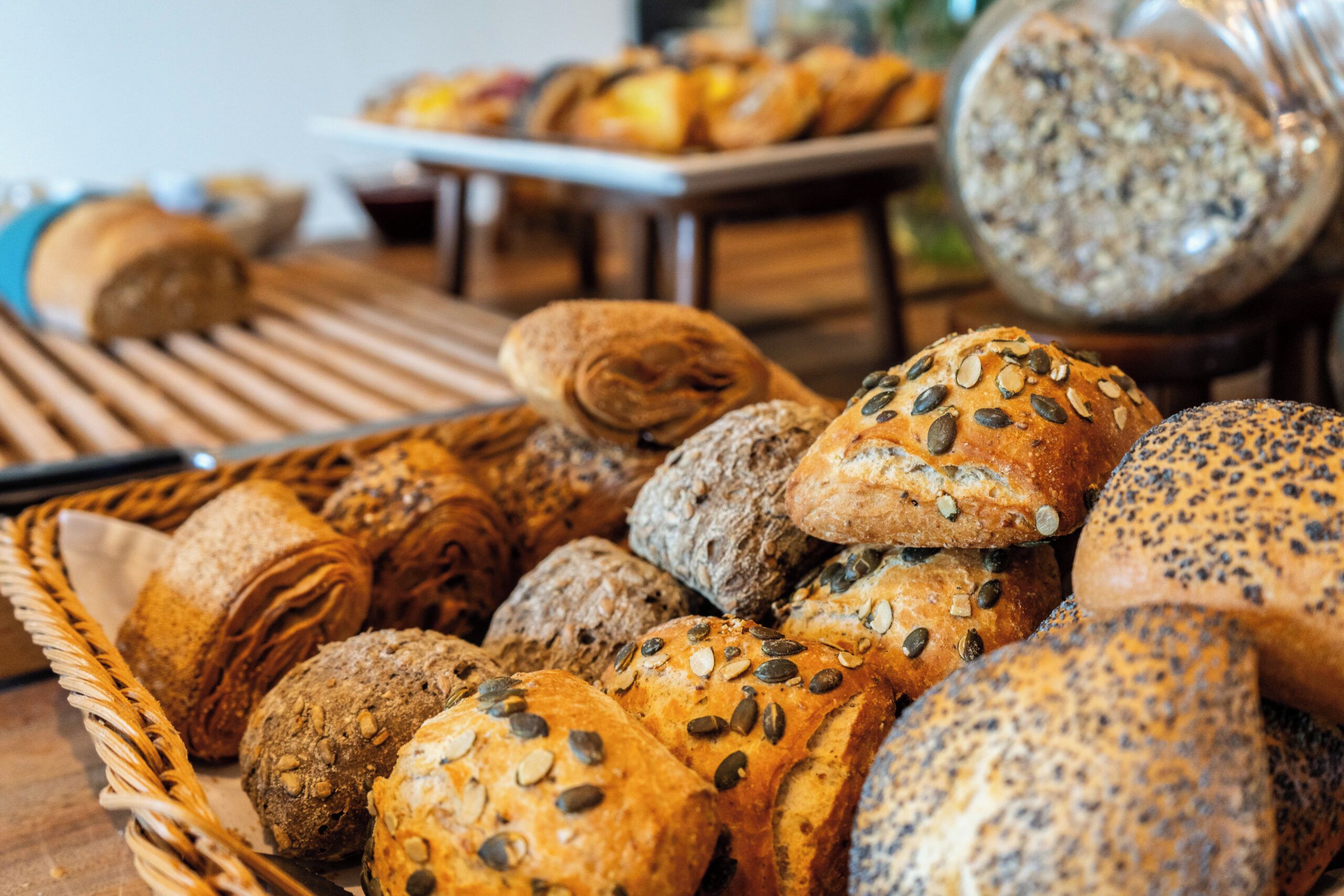 Une variété de pains et de viennoiseries présentés sur une table en bois.