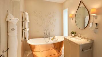 A modern bathroom with a copper bathtub, a large mirror, and a wall-mounted towel rack.