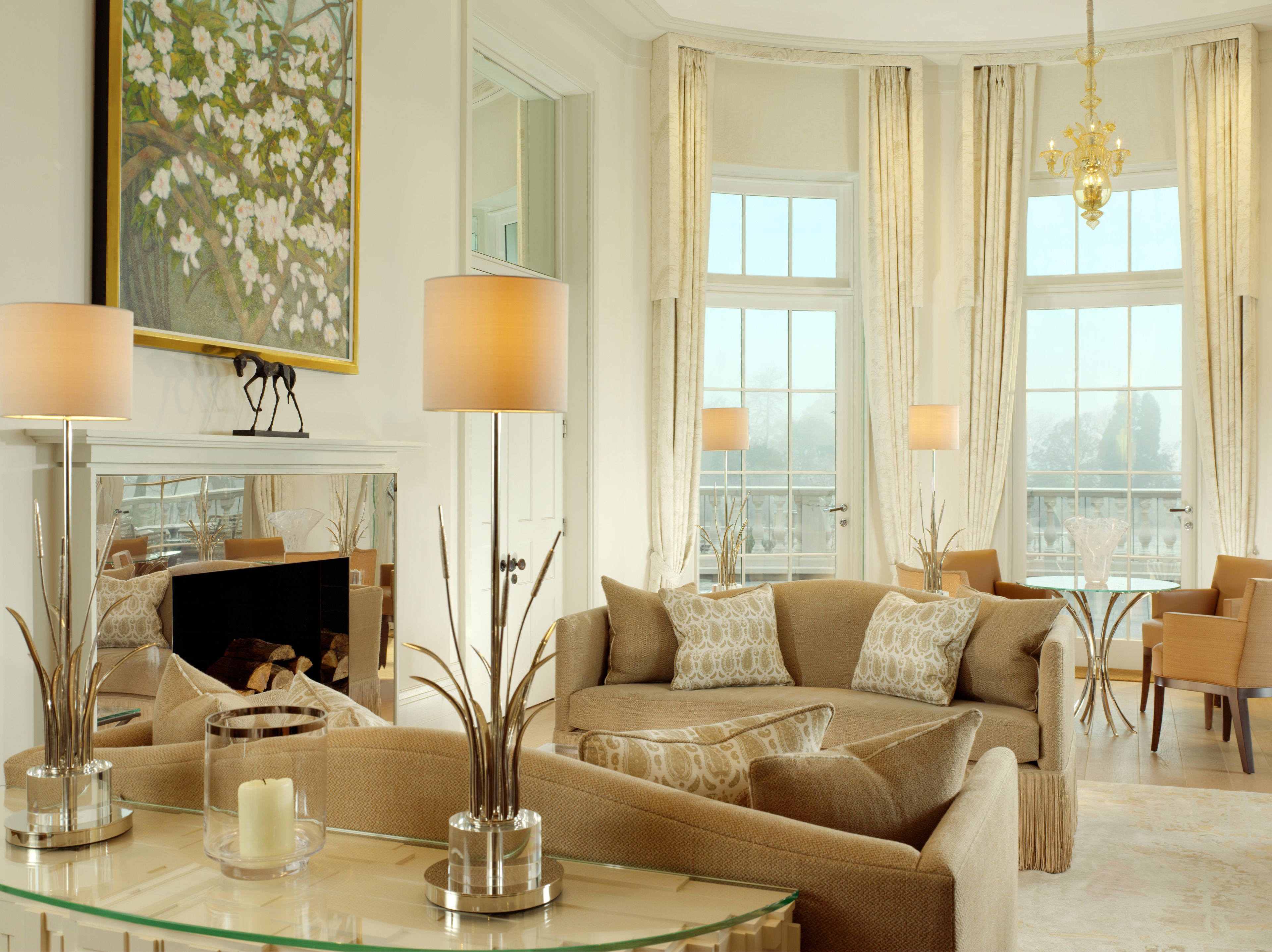 A spacious living room with a sofa set, a glass coffee table, and a fireplace.
