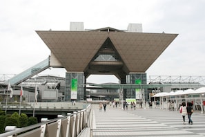 A modern architectural structure with a large, triangular roof and a pedestrian walkway. - Ginza International Hotel (Tokyo)