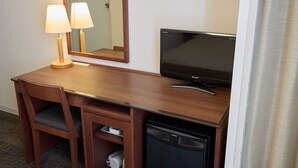 A wooden desk with a television, a lamp, and a small refrigerator. - Ginza International Hotel (Tokyo)