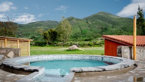 A stone pool with a mosaic edge, surrounded by a stone patio. - Killawasi Lodge (Yanque)