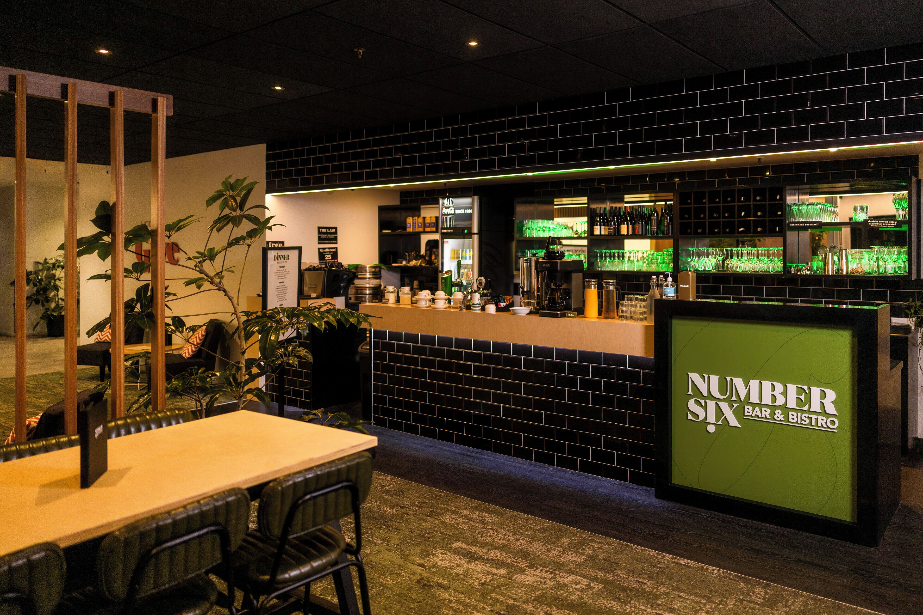Una zona de bar con mostrador, asientos y un tablero de menú.