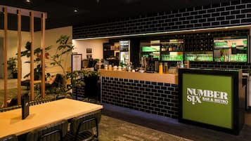 Una zona de bar con mostrador, asientos y un tablero de menú.
