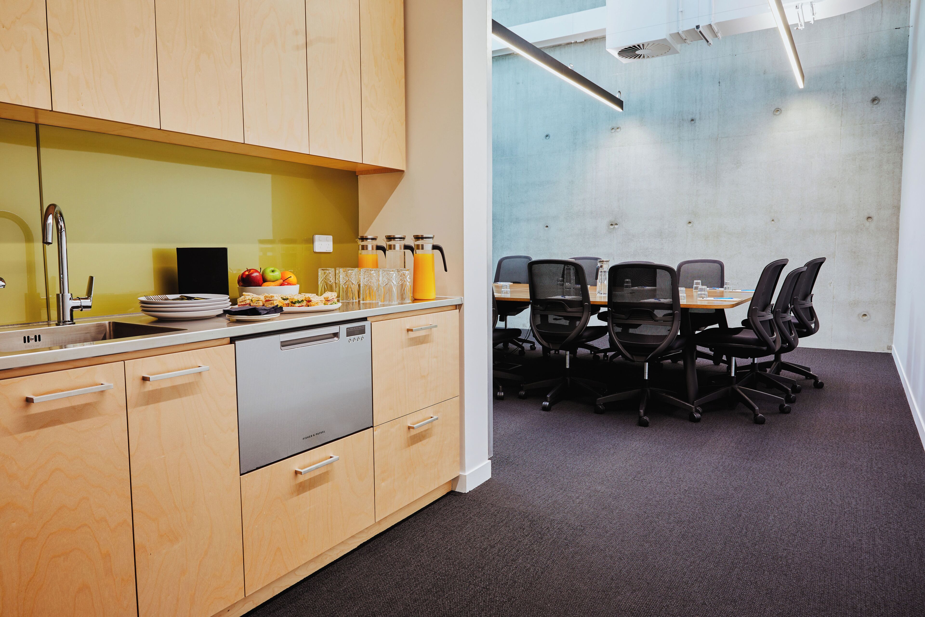 A modern kitchen with a dishwasher, a sink, and a fruit bowl.