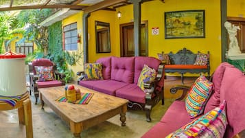 A cozy room with a wooden coffee table, a purple sofa, and a bench with colorful cushions.