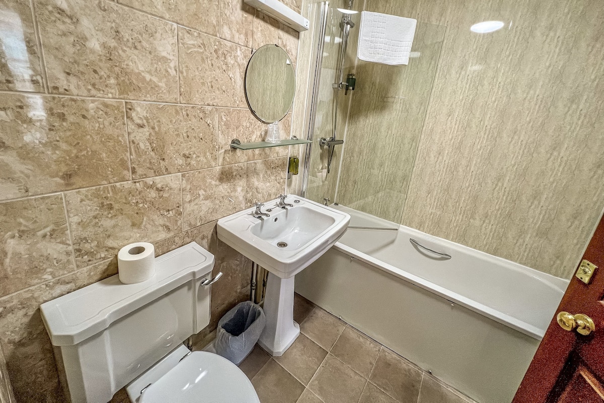 A bathroom with a toilet, sink, mirror, shower, and bathtub.