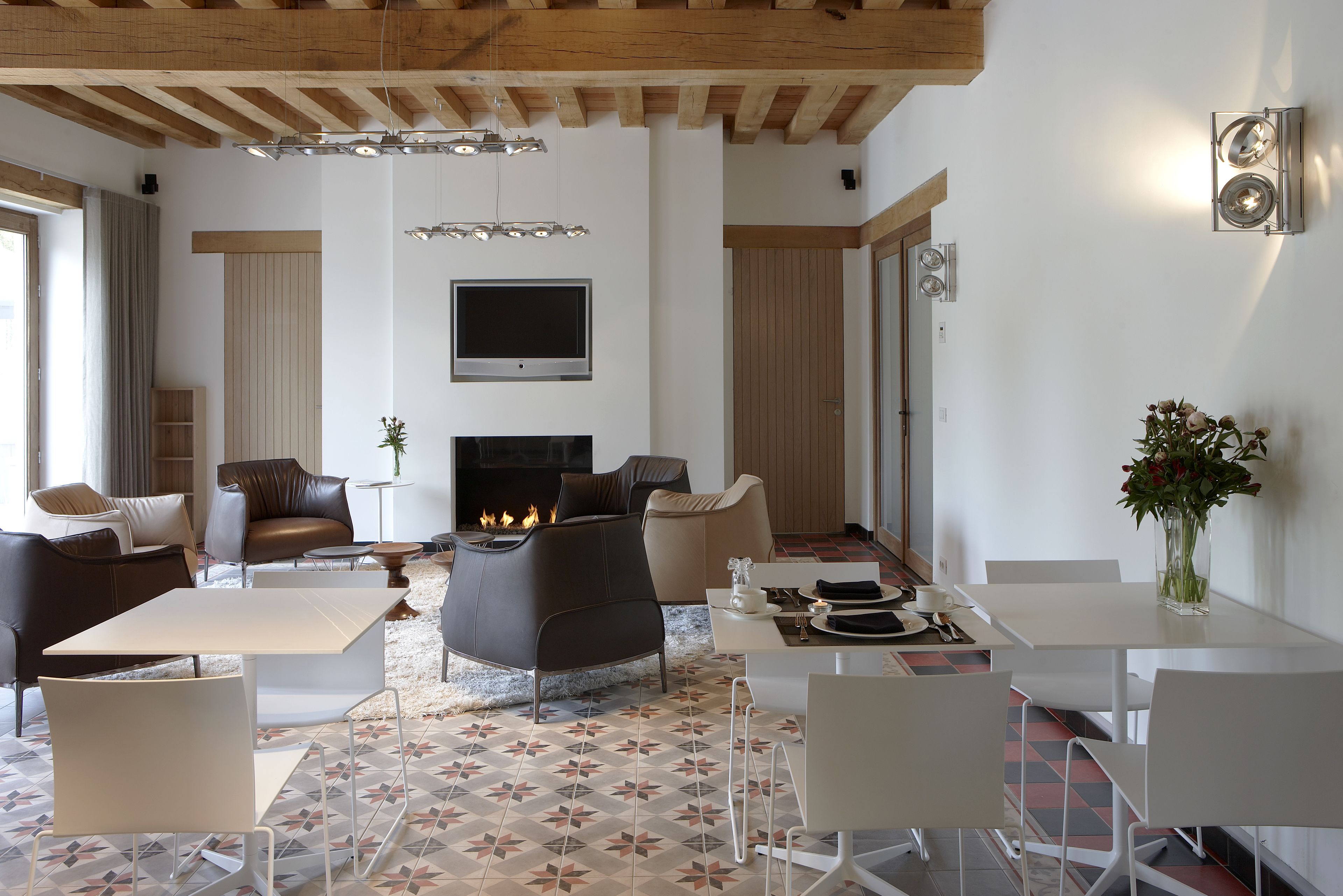 A modern living room with a fireplace, comfortable seating, and a dining area.