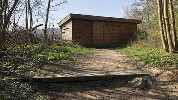 A wooden building with the inscription "DE DOOEL BEMDE" and "GROTE BRON" on its side.
