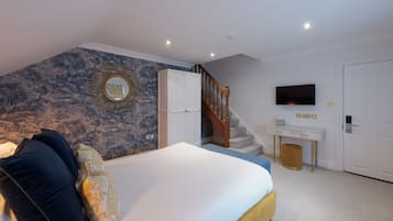 Ein Schlafzimmer mit einem Bett, einem Schminktisch, einem Fernseher und einer Treppe.