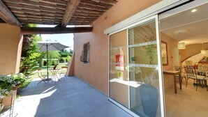 A covered patio area with a sliding glass door leading to a dining area. - Le Mas du Colombier (Cadenet)
